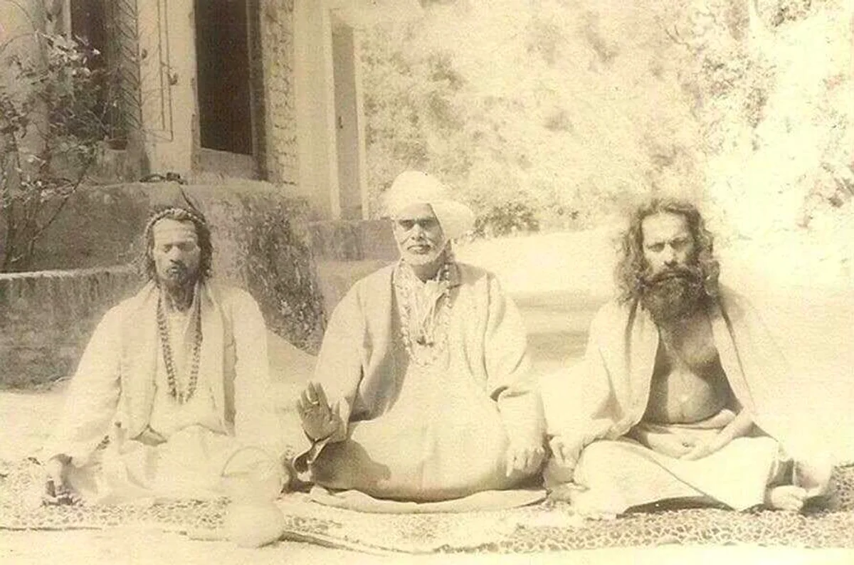 Historische Aufnahme: drei Meister der Linie sitzen in Meditationshaltung vor einem Haus